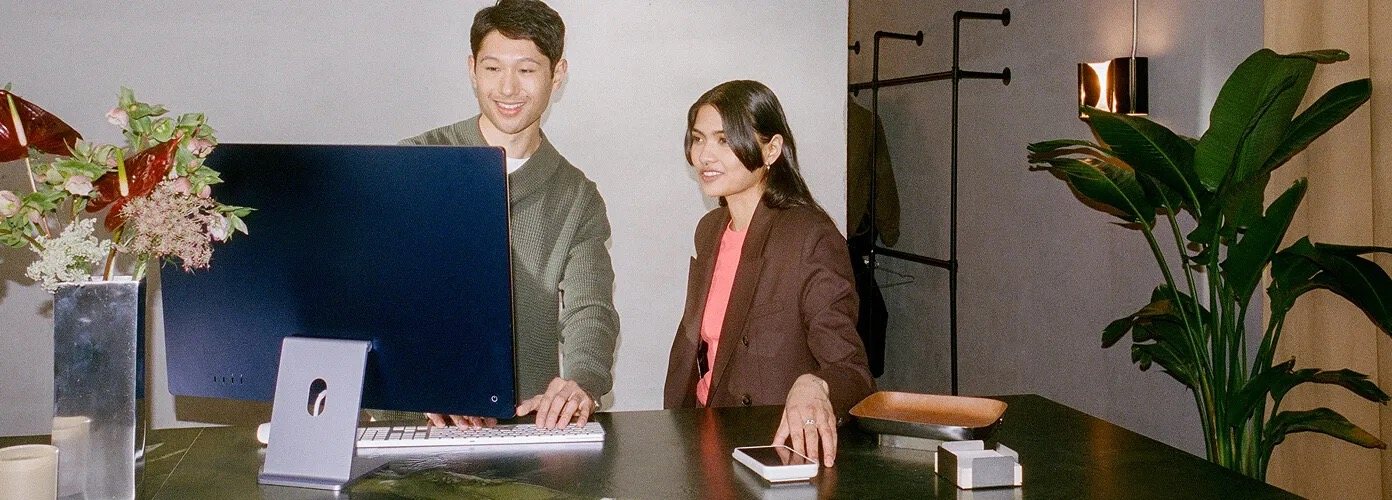 Two shop owners looking at their dashboard at the counter