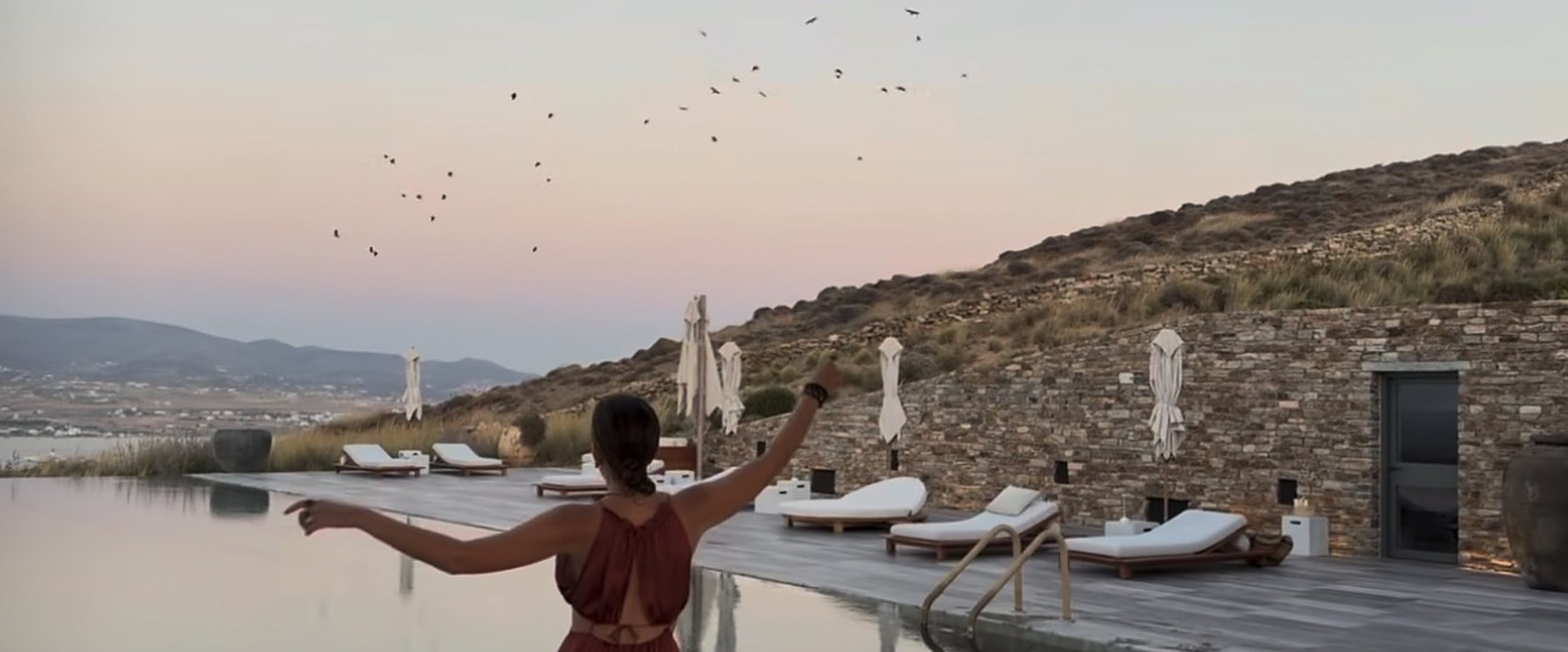 A pool terrace above the sea at sunset